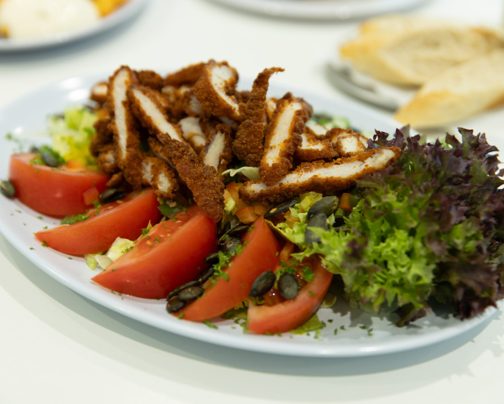 Ein appetitlicher Salatteller mit Tomaten, Blattsalat udn Putenbruststreifen.