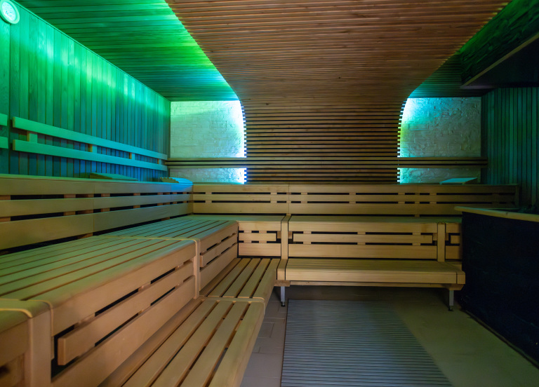 Die leere, beleuchtete, Sauna mit Holzbänken.