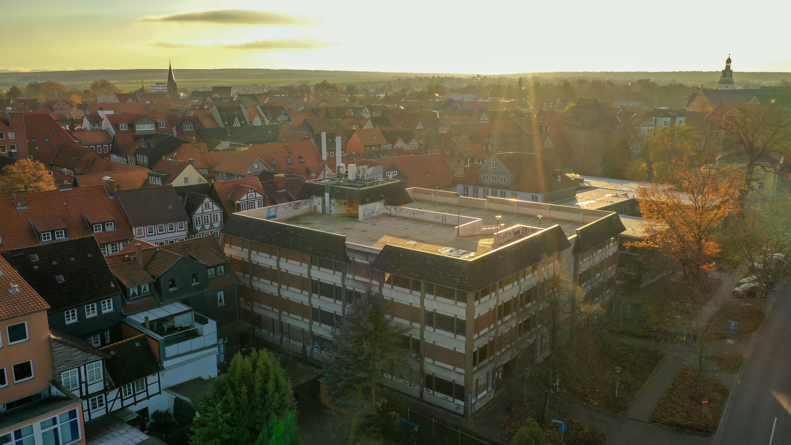 Ein Blick von oben auf das Dachparkdeck des Parkhauses inmitten der historischen Fachwerkkulisse der Stadt Wolfenbüttel.